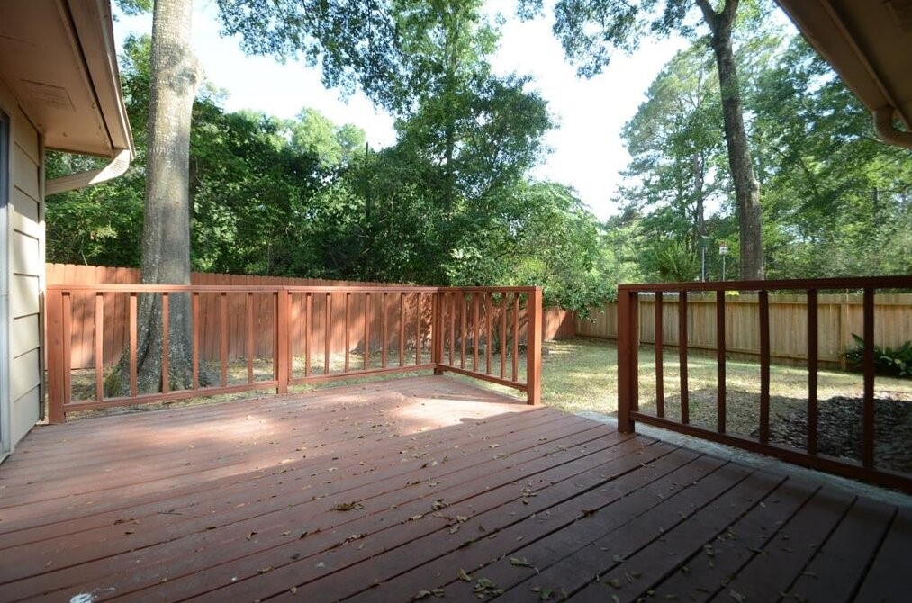 15 South Tallowberry Drive Spring, TX 77381 - Photo 24 of 26 Spacious wooden deck overlooking a fenced, tree-lined backyard, offering a private and serene space for relaxing or entertaining.