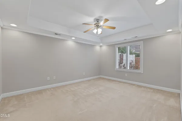 a view of an empty room with wooden floor fireplace and a window