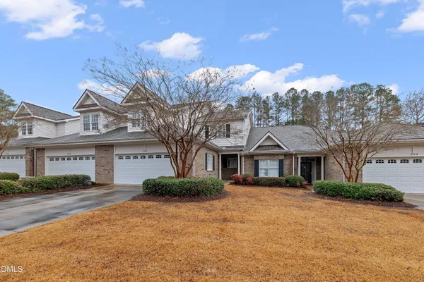 a front view of a house with a yard and trees