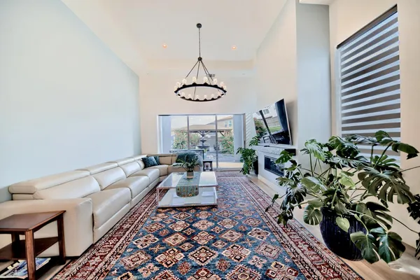 a living room with furniture a dining table and a chandelier