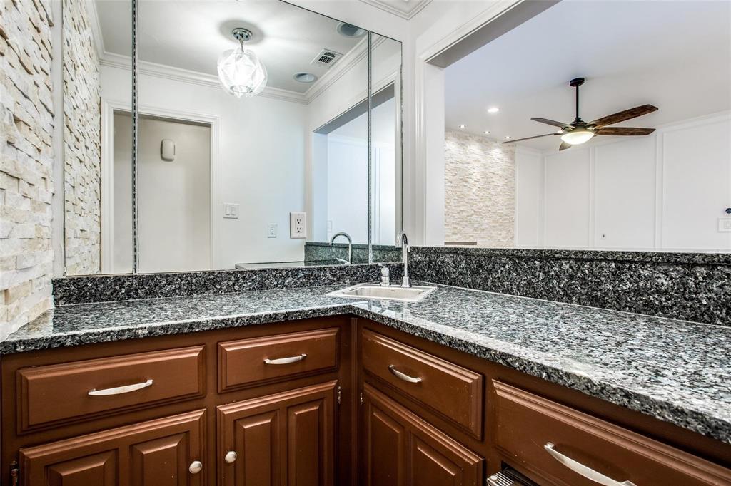 6926 Northwood Road Dallas, TX 75225 - Photo 20 of 29 a sink with granite countertop a sink and a mirror