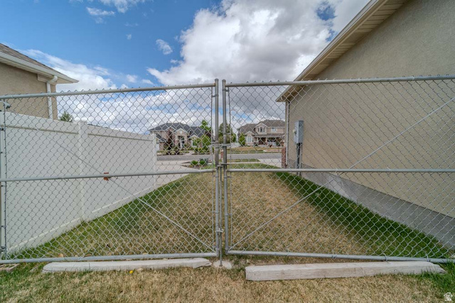 598 Hollow Creek Road Draper, UT 84020 - Photo 99 of 110 Chain link fence enclosing a grassy area, featuring a white vinyl privacy fence