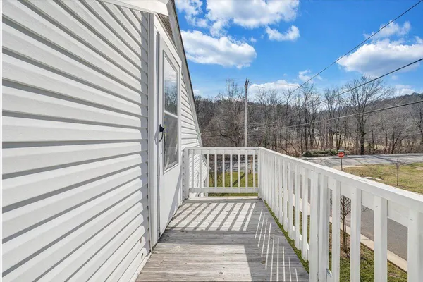 a view of a balcony with wooden floor and fence