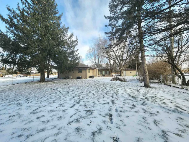 a view of a house with a yard covered with snow