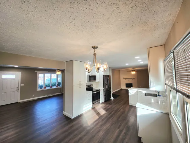 an open kitchen with refrigerator and windows