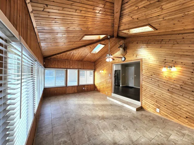a view of a porch with a floor to ceiling window and brick wall