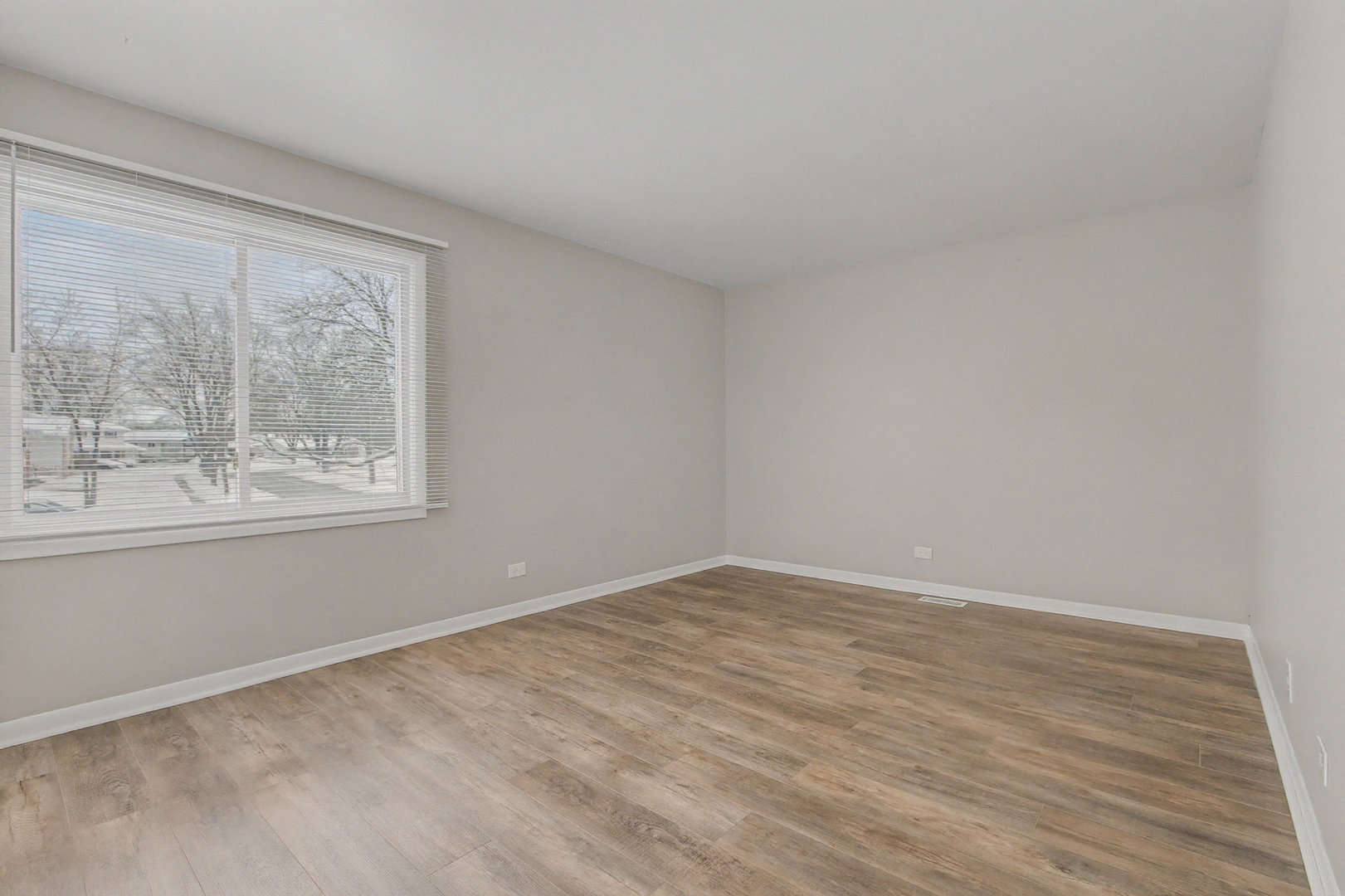 2932 Roberts Drive, Unit 7 Woodridge, IL 60517 - Photo 11 of 28 a view of an empty room with wooden floor and a window