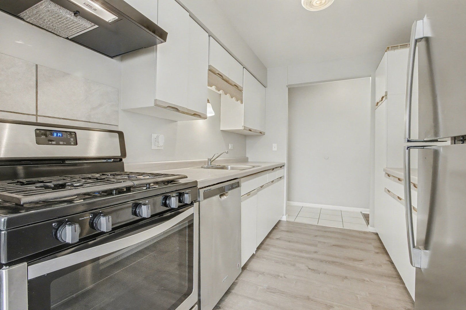 2932 Roberts Drive, Unit 7 Woodridge, IL 60517 - Photo 6 of 28 a kitchen with stainless steel appliances granite countertop a stove and a refrigerator