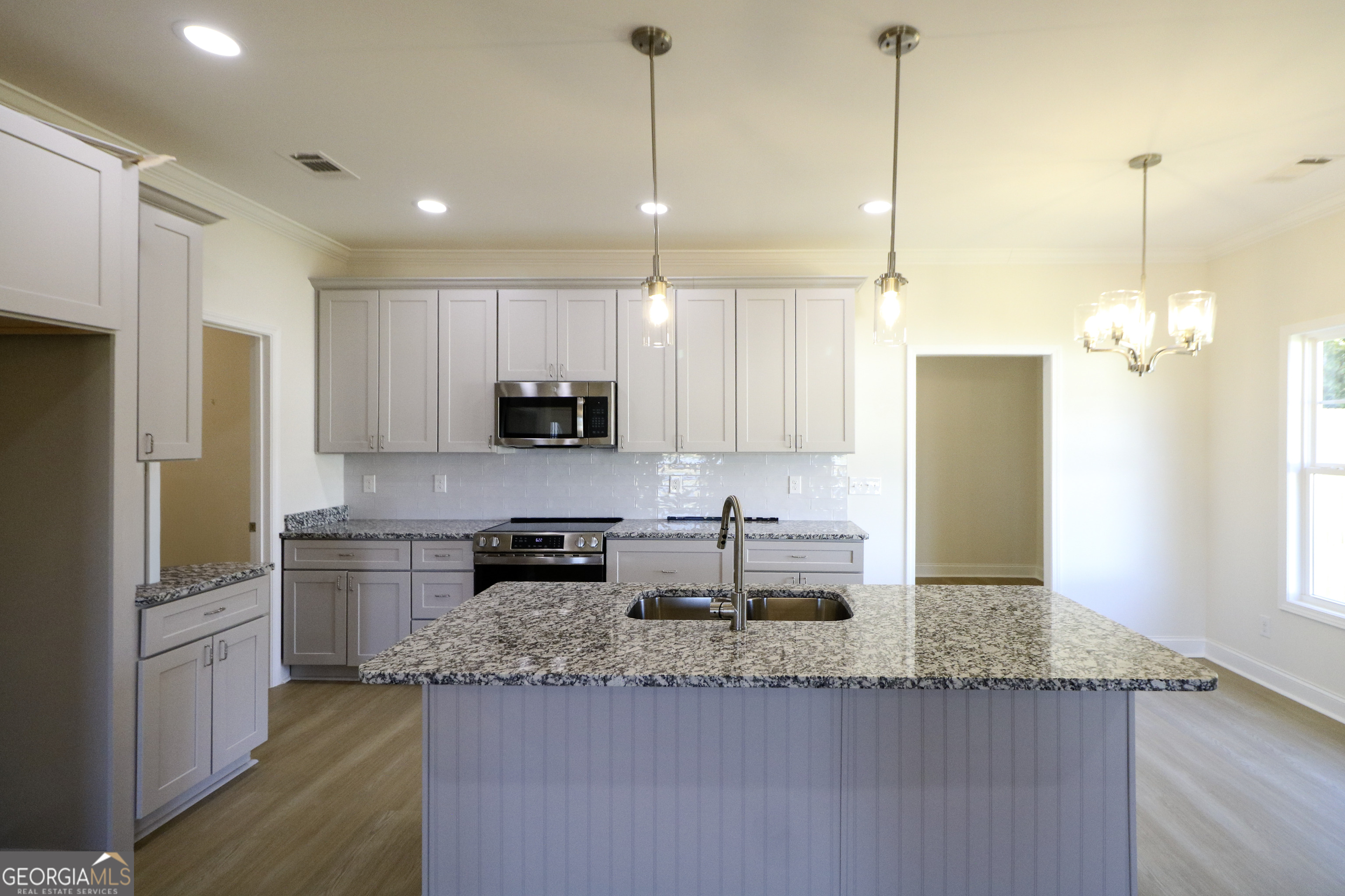 115 Sutter Butte Place Bonaire, GA 31005 - Photo 10 of 38 a kitchen with kitchen island granite countertop a sink a center island a stove and a refrigerator