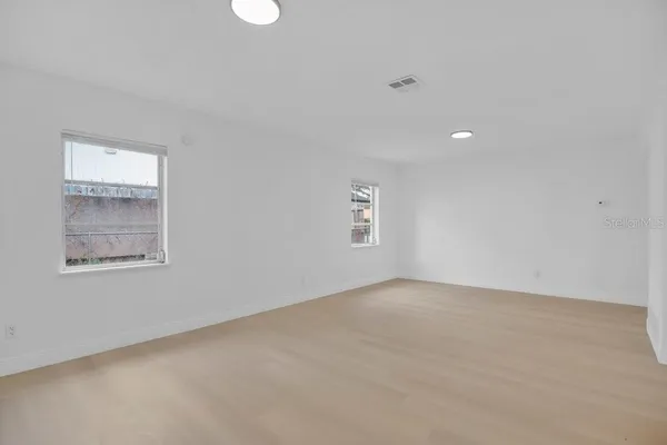 an empty room with windows and closet