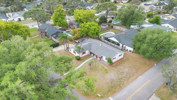 an aerial view of residential houses with outdoor space and trees