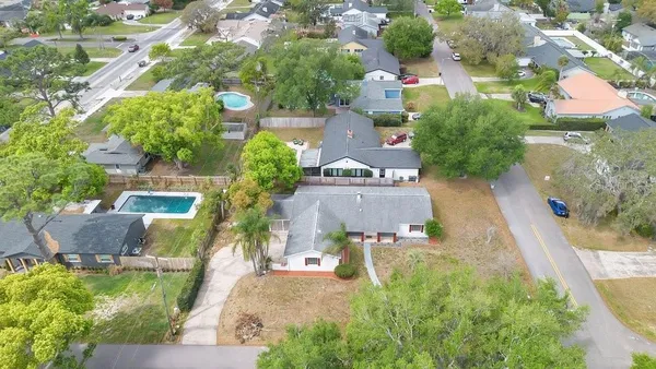 an aerial view of residential houses with outdoor space and trees all around