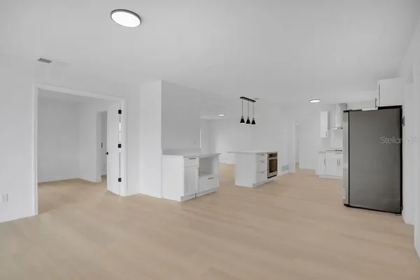 a view of a kitchen with refrigerator and a sink