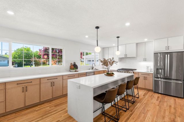 a kitchen with white cabinets stove and refrigerator