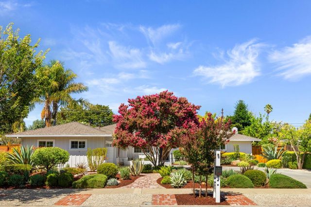 a front view of a house with a yard and tree s