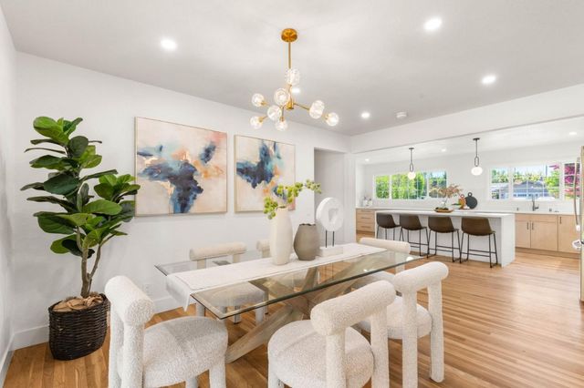 a dining room filled chandelier and wooden floor