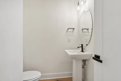 a bathroom with a sink toilet and mirror