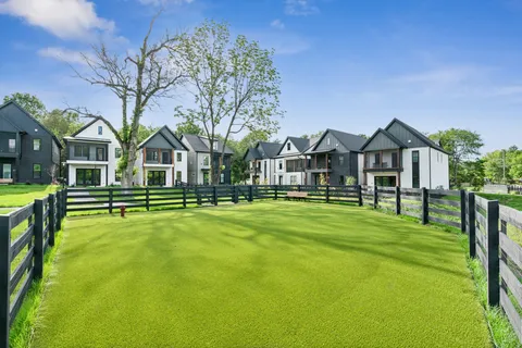 a view of a house with a big yard and large trees
