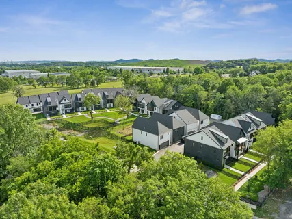 an aerial view of a house with a garden and lake view