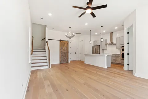 a view of a kitchen with wooden floor and a ceiling fan