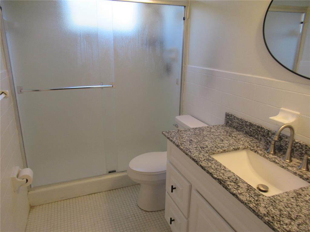 2073 Denmark Street, Unit 5 Clearwater, FL 33763 - Photo 13 of 23 a bathroom with a granite countertop sink and a mirror