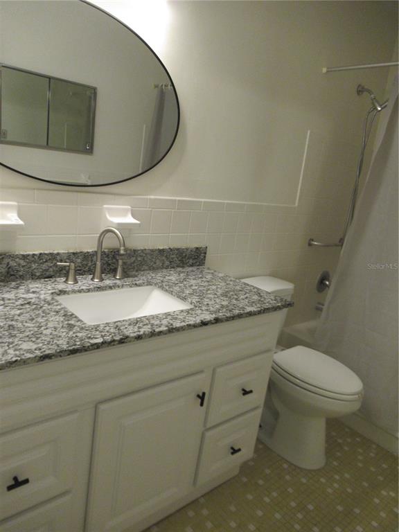 2073 Denmark Street, Unit 5 Clearwater, FL 33763 - Photo 21 of 23 a bathroom with a granite countertop toilet sink and mirror