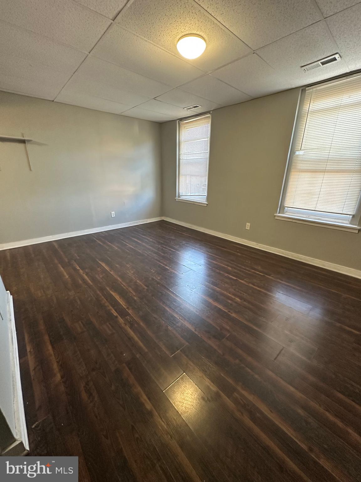 525-527 Penn Street, Unit 1B Camden, NJ 08102 - Photo 4 of 10 an empty room with wooden floor and windows