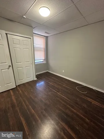 an empty room with wooden floor and window