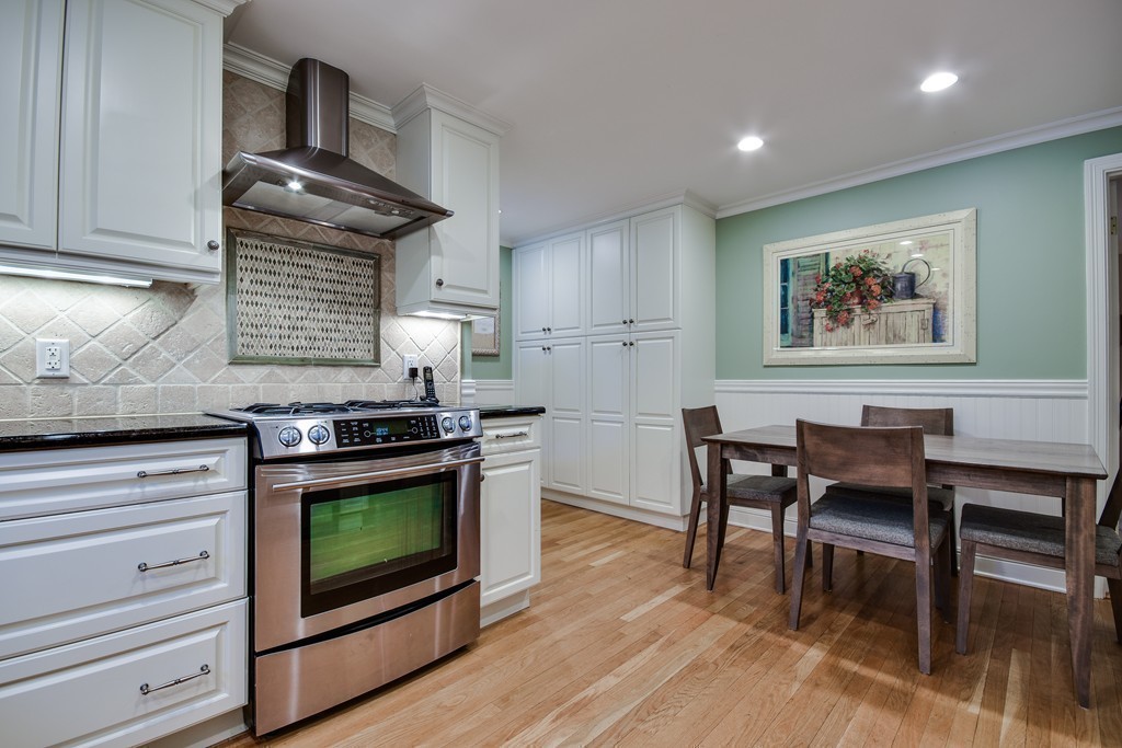 33 Oakridge Road Wellesley, MA 02481 - Photo 12 of 27 a kitchen with stainless steel appliances wooden floor dining table and chair