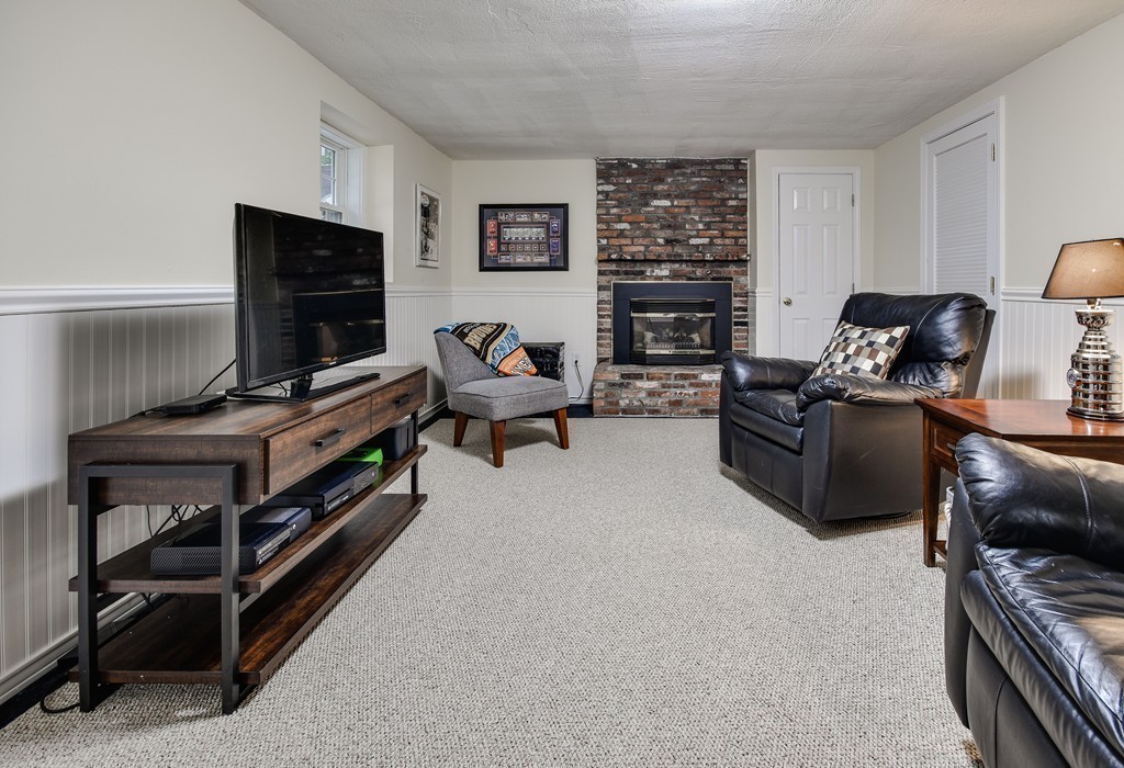 33 Oakridge Road Wellesley, MA 02481 - Photo 25 of 27 a living room with furniture a flat screen tv and a fireplace