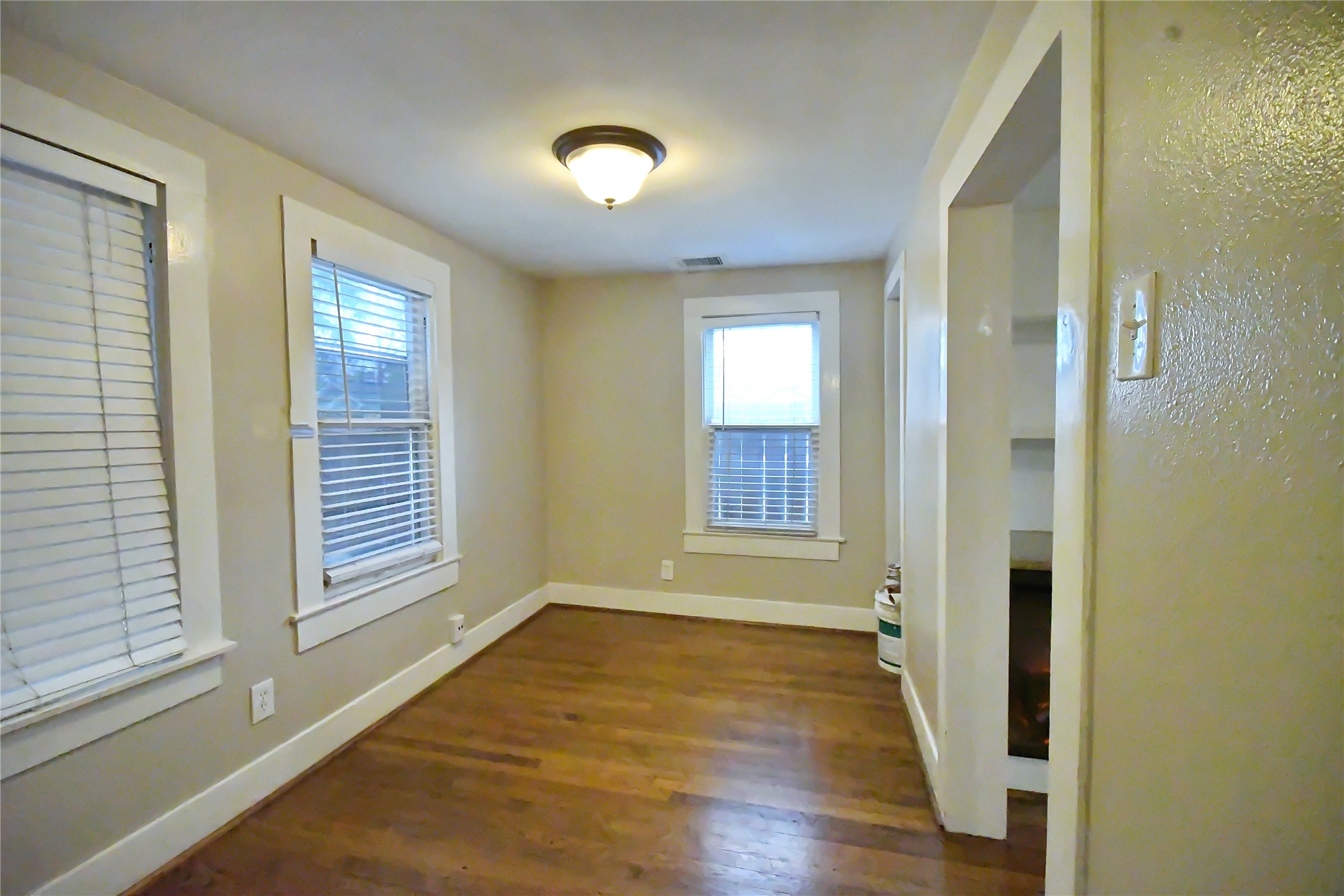 1209 Studewood Street Houston, TX 77008 - Photo 4 of 18 an empty room with wooden floor and windows