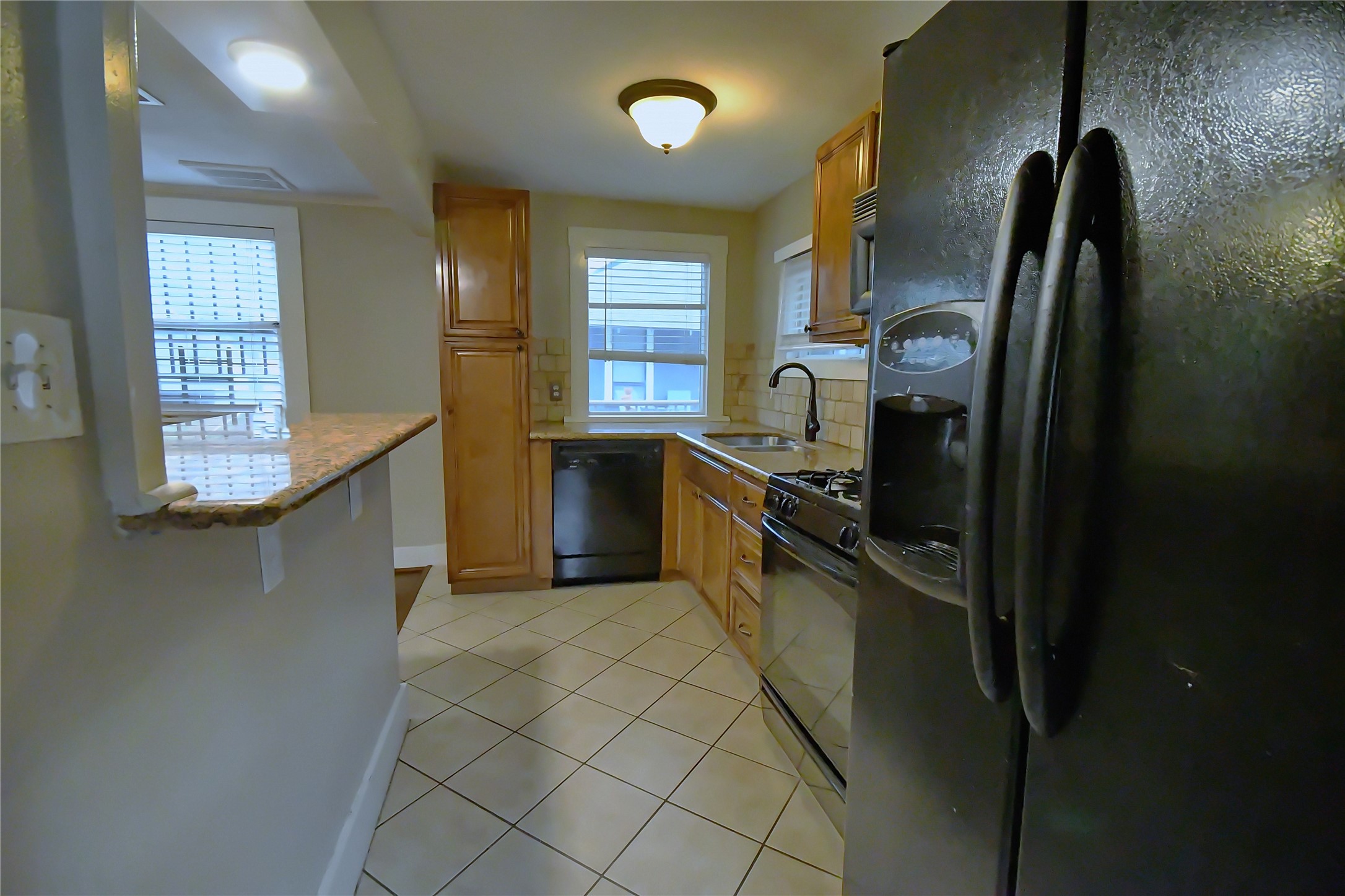 1209 Studewood Street Houston, TX 77008 - Photo 7 of 18 a kitchen with stainless steel appliances granite countertop a sink a stove a refrigerator a washer dryer and a dining table