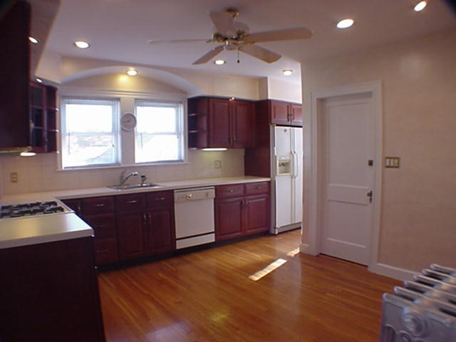 8-10 Kenrick Street, Unit 10 Boston, MA 02135 - Photo 11 of 28 a kitchen with granite countertop a sink cabinets and wooden floor