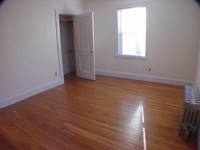 8-10 Kenrick Street, Unit 10 Boston, MA 02135 - Photo 17 of 28 an empty room with wooden floor and windows