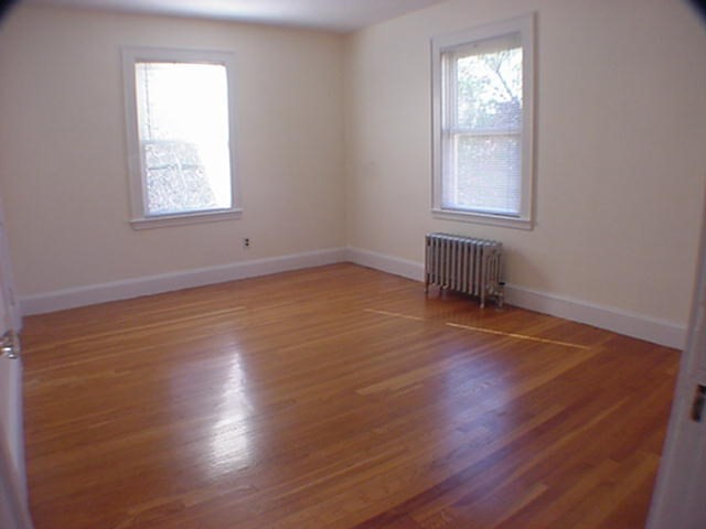 8-10 Kenrick Street, Unit 10 Boston, MA 02135 - Photo 18 of 28 an empty room with wooden floor and windows