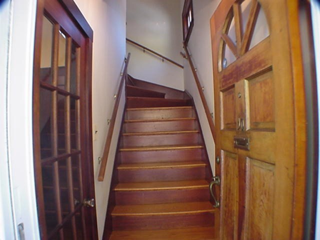 8-10 Kenrick Street, Unit 10 Boston, MA 02135 - Photo 2 of 28 a view of staircase with wooden floor and a railing