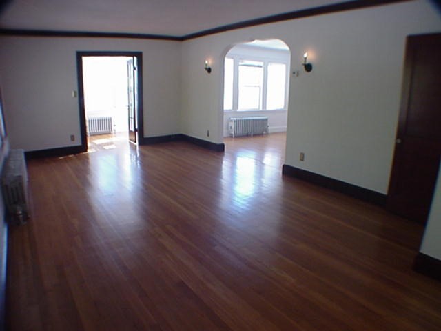 8-10 Kenrick Street, Unit 10 Boston, MA 02135 - Photo 3 of 28 an empty room with wooden floor and windows