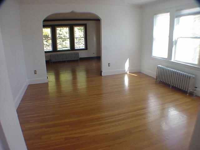 8-10 Kenrick Street, Unit 10 Boston, MA 02135 - Photo 10 of 28 a view of empty room with wooden floor and fan