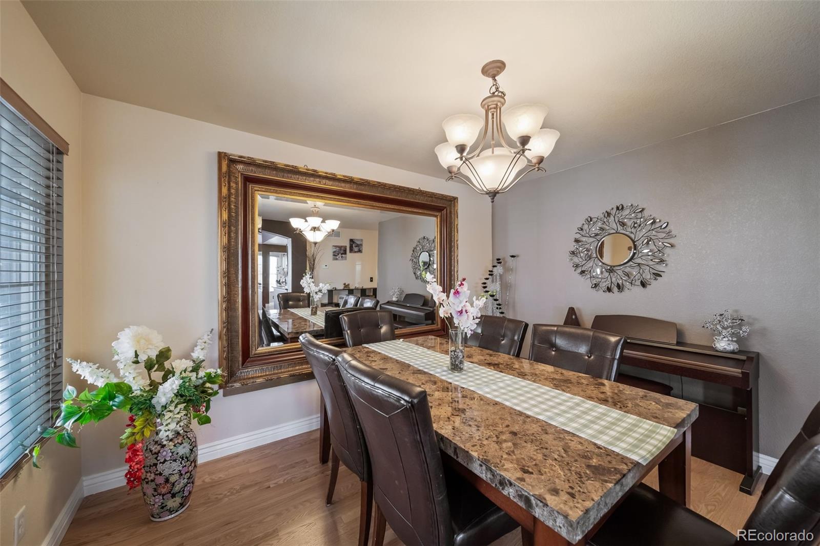 3041 South Jericho Way Aurora, CO 80013 - Photo 18 of 46 a view of a dining room with furniture a chandelier and wooden floor
