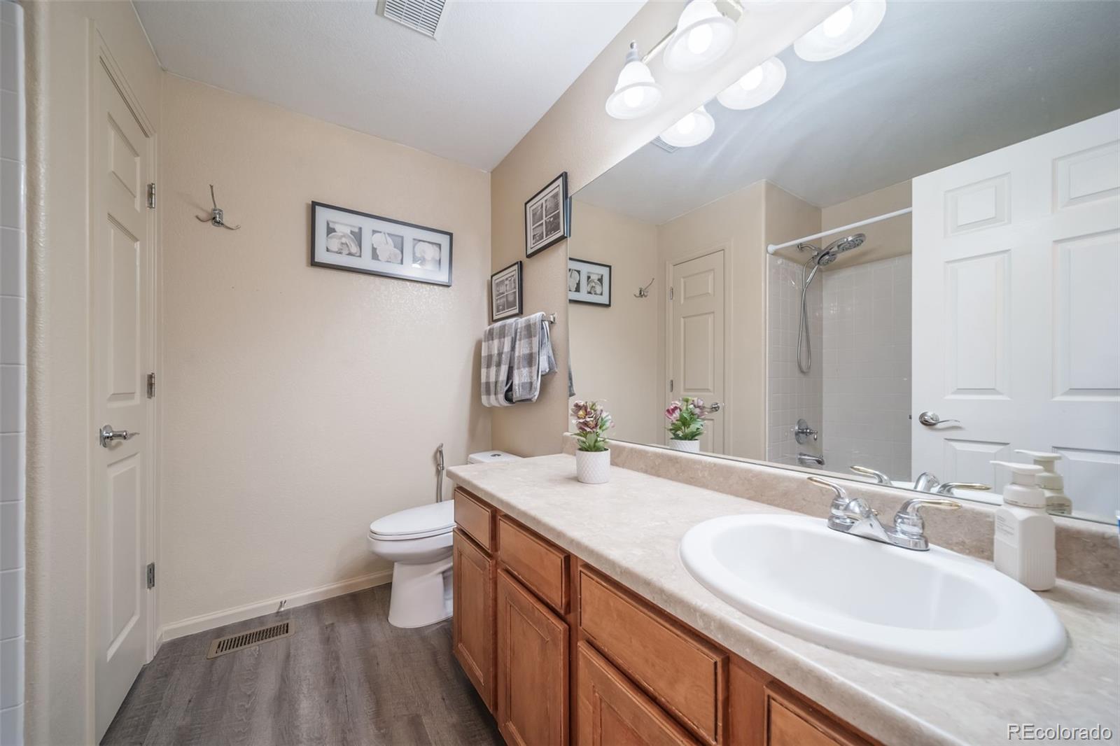 3041 South Jericho Way Aurora, CO 80013 - Photo 34 of 46 a bathroom with a sink a toilet and a large mirror