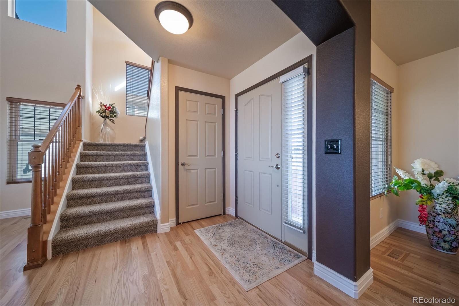 3041 South Jericho Way Aurora, CO 80013 - Photo 6 of 46 a view of a hallway with wooden floor and stairs