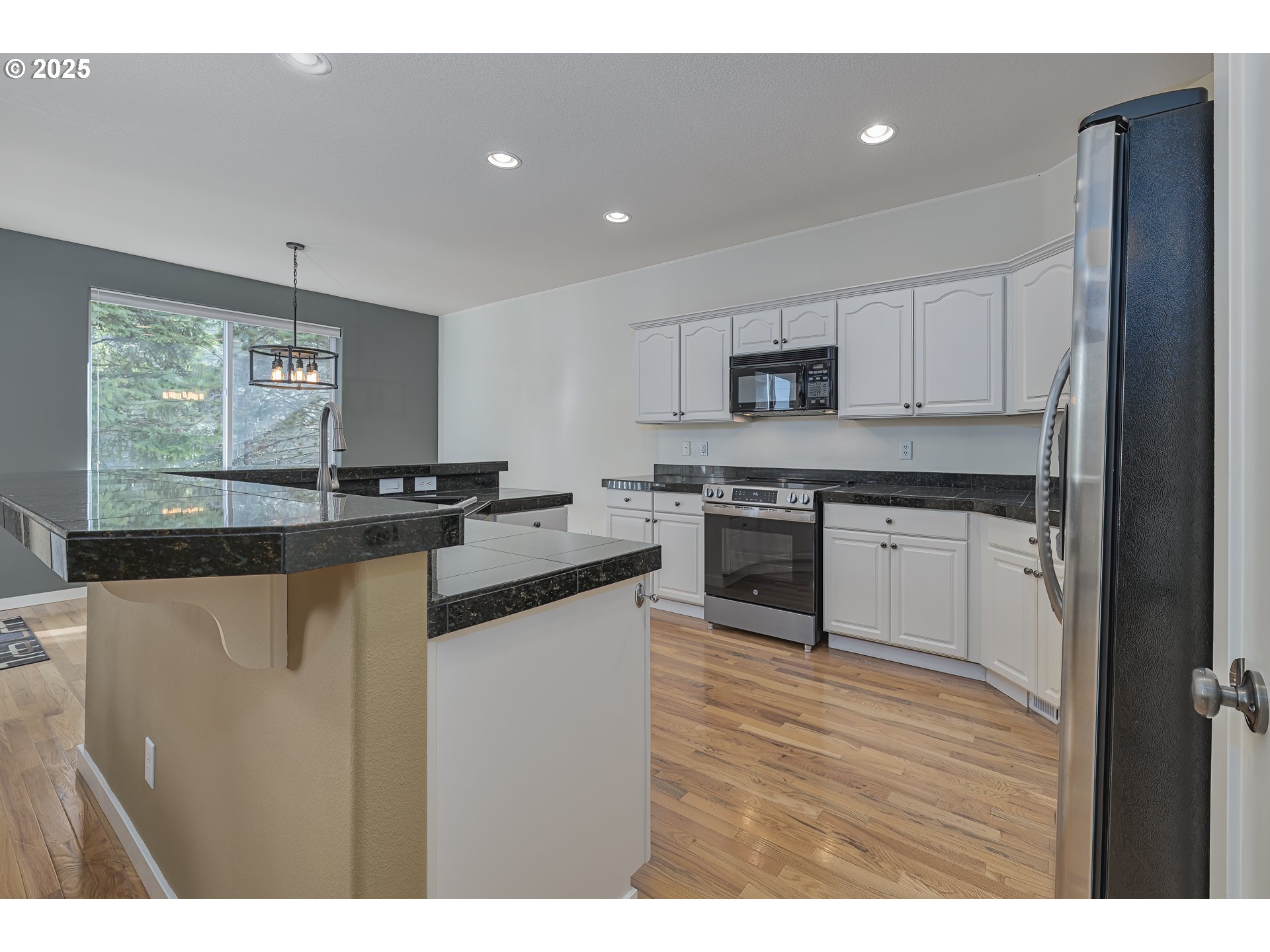 384 Southwest 105th Terrace Portland, OR 97225 - Photo 7 of 30 a kitchen with stainless steel appliances granite countertop a stove a sink and a microwave
