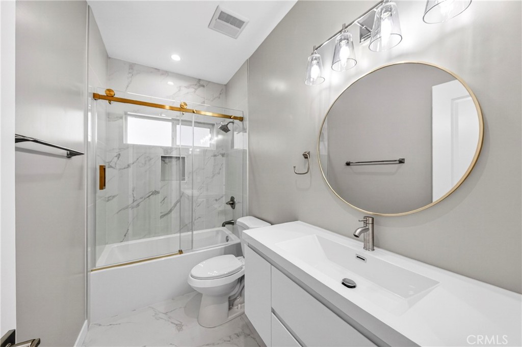 2643 Tenth Street Riverside, CA 92507 - Photo 15 of 40 a bathroom with a toilet a sink and a mirror