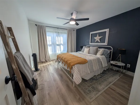 a bedroom with a bed and wooden floor