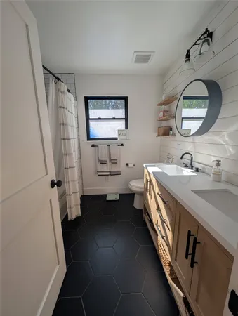 a bathroom with a double vanity sink mirror and toilet