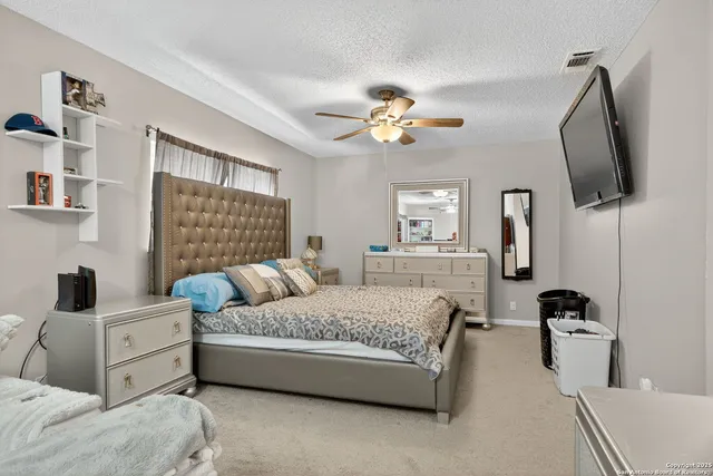a bedroom with a large bed a flat tv screen and dresser