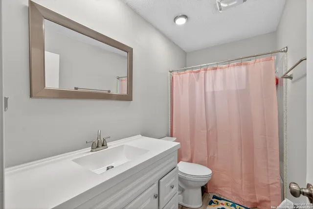 a bathroom with a sink a toilet and a mirror