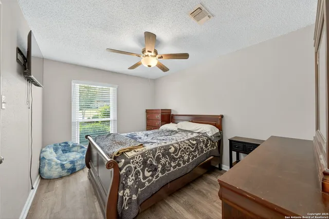 a bedroom with a bed a window and a flat screen tv