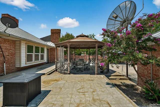 a view of a house with backyard and sitting area