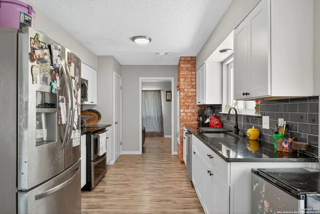 a kitchen with stainless steel appliances granite countertop a refrigerator and a sink